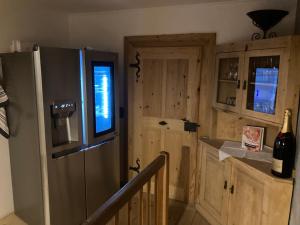 a kitchen with a refrigerator and a counter with a bottle of wine at Appartement Schankwirtschaft in Pfronten