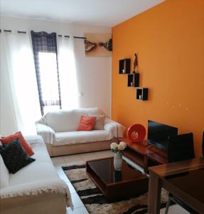 a living room with a couch and a table at Family Apartment in Praia