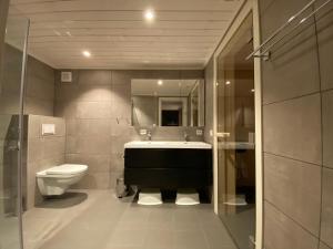 a bathroom with a sink and a toilet at Hytte nær vannet, jacuzzi og sauna in Vradal +80 photos