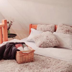 a bed with a basket of blankets and pillows at Planinska kuca Bjelasnica in Sinanovići