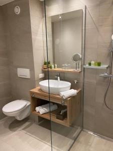 a bathroom with a sink and a toilet and a shower at Vitalhotel Kaiserhof in Seefeld in Tirol