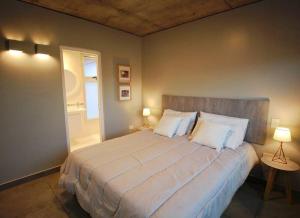una camera da letto con un grande letto bianco con due lampade di Naranjo 9A a San Salvador de Jujuy