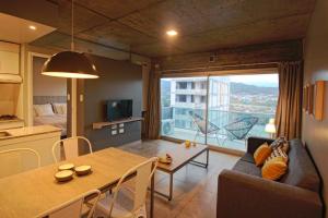 a living room with a couch and a table and a kitchen at Naranjo 9A in San Salvador de Jujuy