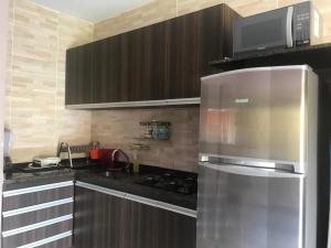 a kitchen with a stainless steel refrigerator and a microwave at Flat WinterVille Residence - Gravatá in Gravatá