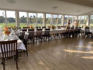 a large dining room with tables and chairs and people at More Guesthouse in More