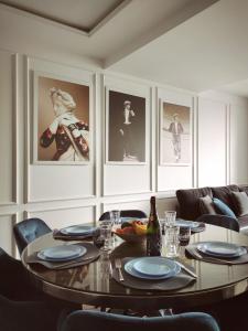 een eetkamer met een tafel en wat foto's bij Modern Classic 2 bedroom apartment near Most City in Dnipro