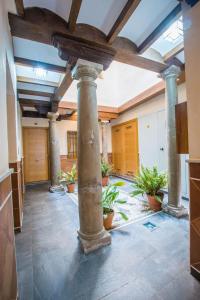 una grande stanza con colonne e piante in vaso di Apartamento céntrico a 10 minutos de la Alhambra a Granada
