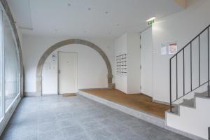 un corridoio vuoto con un arco e una porta di Habitatio - Foz a Porto