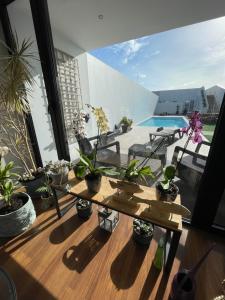 a balcony with a table and potted plants on it at Praia de Santos, Exclusive Villa, Açores in Ponta Delgada