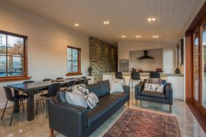salon z kanapą i stołem w obiekcie The Homestead on Wilding by Sotheby's Luxury Rental Homes w mieście Arrowtown