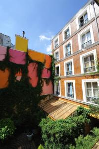 un edificio con una terraza de madera delante de él en Les Patios du Marais 1, en París