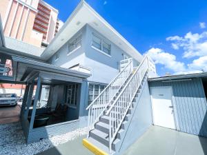 a white house with a staircase in front of it at Sunrise Resort Motel South in Clearwater Beach