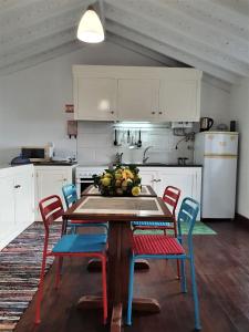 a kitchen with a table with chairs and fruit on it at Casa São Miguel in São Roque do Pico