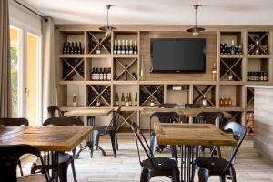 een restaurant met tafels en stoelen en een flatscreen-tv bij Best Western Le Vauban in Prades