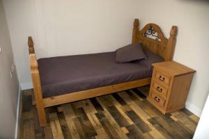 un letto con struttura in legno e comodino di Casa Totalmente Renovada en Zona muy Tranquila!!! Vistas al Mar y Montaña a Buenavista del Norte