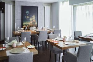 une salle à manger avec des tables et des chaises en bois dans l'établissement Belgrade Art Hotel, a member of Radisson Individuals, à Belgrade