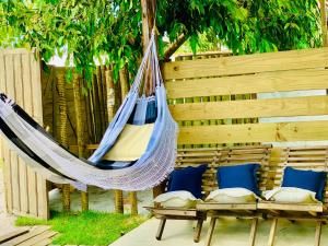 Una hamaca colgada de una valla de madera con almohadas. en Casa do sol, en Caraíva