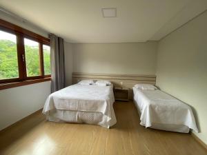 a room with two beds and a window at Katuny Pousada e Eventos in São Domingos do Prata +25 photos