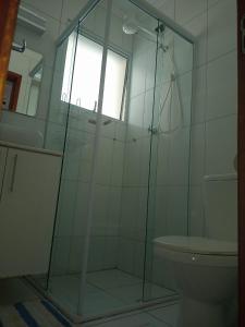een badkamer met een douche, een toilet en een raam bij Ubatuba - Sunway in Ubatuba