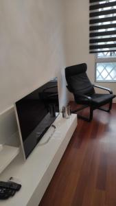 czarne krzesło siedzące na białym stole z telewizorem w obiekcie Luxury apartment arinaga w mieście Arinaga