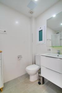 biała łazienka z toaletą i umywalką w obiekcie Neues Apartment am Strand w mieście Arguineguín