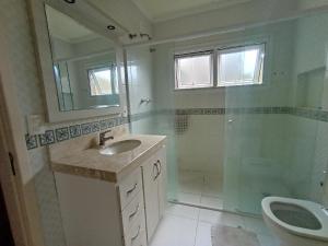 y baño con lavabo, ducha y aseo. en Amplo e Central Apartamento 3 Quartos, en Gramado