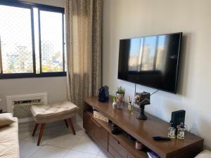 uma sala de estar com uma televisão de ecrã plano na parede em Apartamento 3 Dormitórios / Praia Enseada Guarujá, Piscina, Vista ao fundo e sol da manhã!. no Guarujá