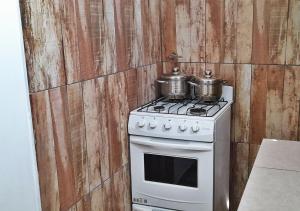 una cocina con 2 ollas en una estufa en Departamento en El Calafate para dos personas en El Calafate