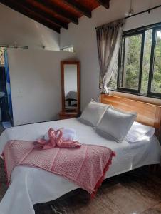 a bedroom with a bed with a pink towel on it at HOTEL EL POTRILLO in El Peñol