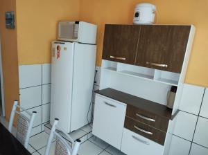 a kitchen with a white refrigerator and a microwave at Apartamento Dulplex Diária/Temporada in Angra dos Reis