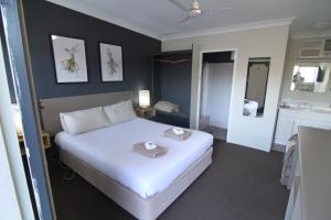 a bedroom with a large white bed in a room at Motel Melrose in Mittagong