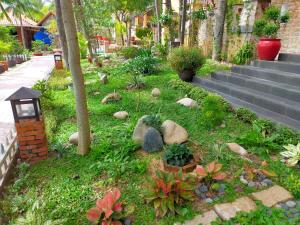 a garden with rocks and plants next to stairs at Hon Rom Central Beach Resort in Mui Ne