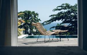 a pair of chairs sitting next to a pool at Salty Breeze Bali in Ungasan
