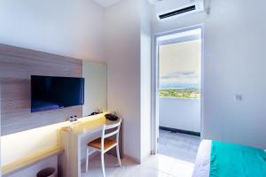 a bedroom with a desk and a tv on a wall at Nivasa Nusa Dua in Ungasan