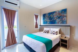 a bedroom with a bed and a large window at Nivasa Nusa Dua in Ungasan