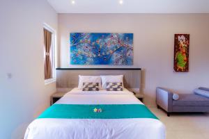a bedroom with a large bed and a couch at Nivasa Nusa Dua in Ungasan