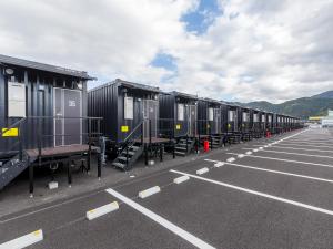 una fila di vagoni ferroviari parcheggiati in un parcheggio di HOTEL R9 The Yard Yatsushiro a Yatsushiro