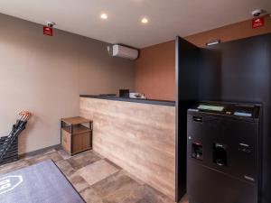 a kitchen with a counter and a refrigerator at HOTEL R9 The Yard Yatsushiro in Yatsushiro