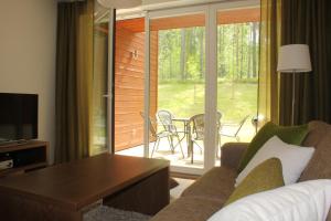 a living room with a couch and a sliding glass door at Marina Holiday Honka Village Apartments in Imatra