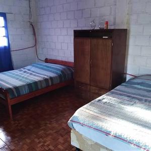 a room with two beds and a dresser in a room at Casa del monte, en cercanía de arroyo y balneario in Puerto Rico