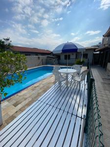 佛羅安那波里的住宿－Excelente casa com piscina na Praia de Ingleses，池畔甲板配有桌椅