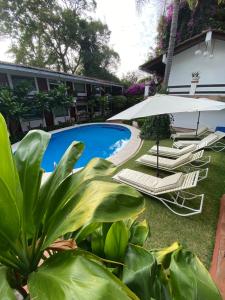 - une piscine avec des chaises longues et un parasol dans l'établissement Casa Dalinda, à Valle de Bravo