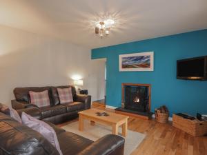 a living room with a couch and a fireplace at Lilac Cottage in Strathpeffer