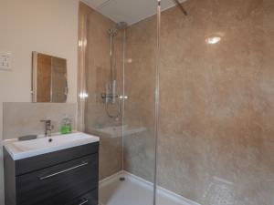 a bathroom with a shower with a sink and a toilet at Lilac Cottage in Strathpeffer +11 photos