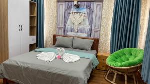 Schlafzimmer mit einem Bett mit grünem Ottomanen in der Unterkunft Sampan House in Cần Thơ