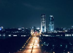 una città illuminata di notte con edifici alti di HillTree Homestay Putrajaya a Putrajaya