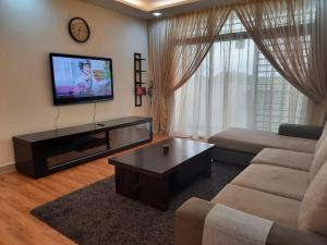 プトラジャヤにあるHillTree Homestay Putrajayaのリビングルーム(ソファ、テレビ付)