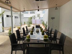 a dining room with a long table and chairs at chillax Thoddoo in Thoddoo