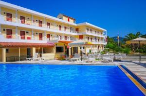 a hotel with a swimming pool in front of a building at Hotel Prassino Nissi in Moraitika