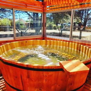 bañera de hidromasaje de madera en una habitación con ventanas en Cabañas Costa Norte, en Algarrobo